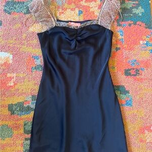 Elegant black mini dress with sheer polka dot sleeves